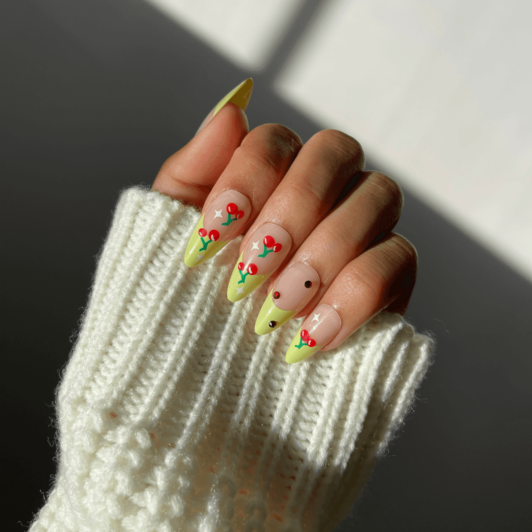 Hand with green and cherry design press-on nails