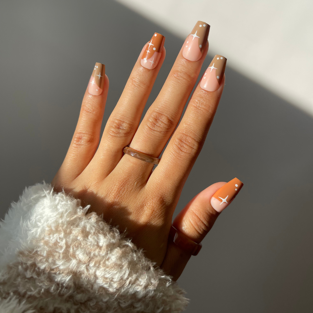 Square medium Hazel ombre nails with star design in brown and nude.
