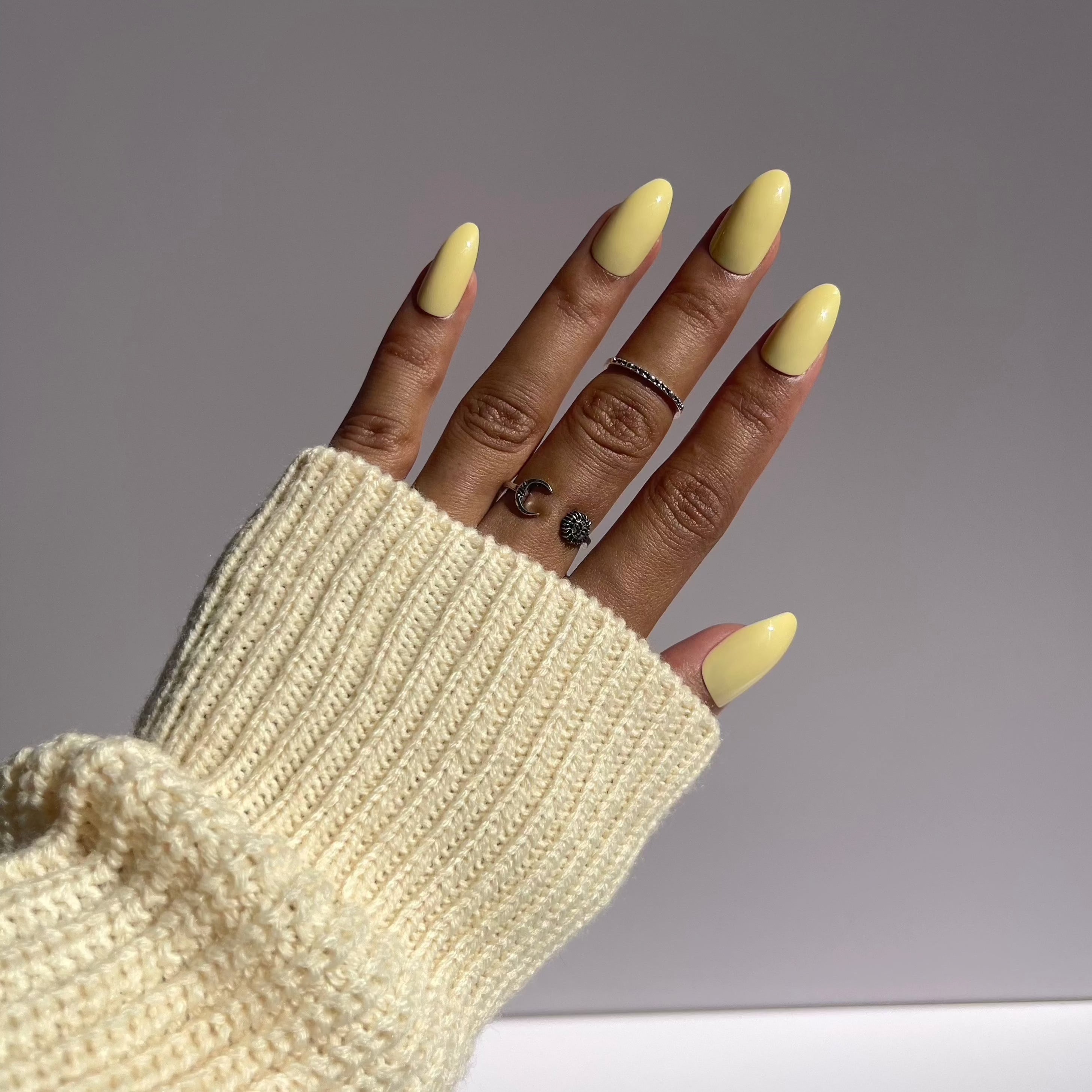 Elegant pastel yellow nails with knit sweater