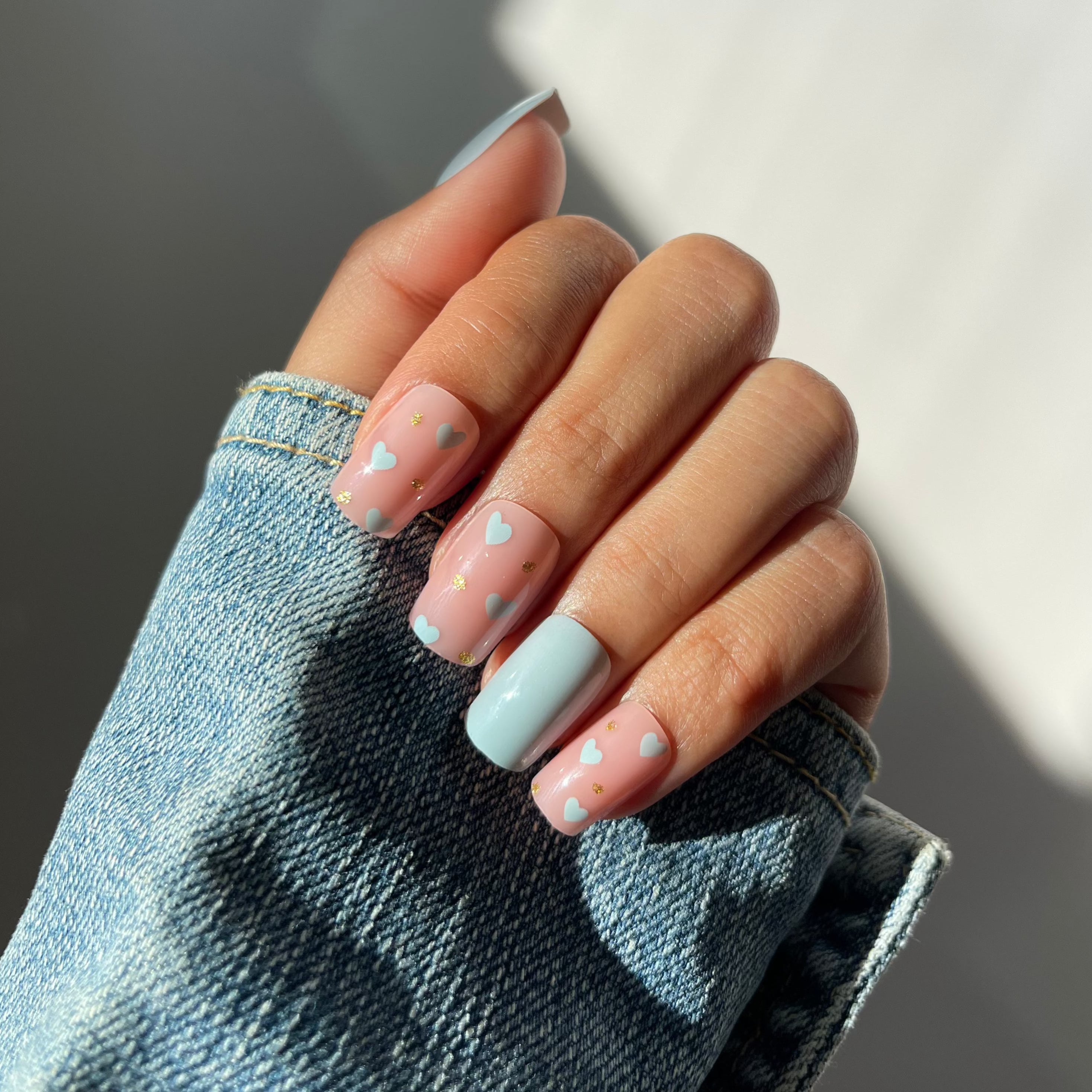 Mila press-on nails in baby blue and blush pink with heart design.