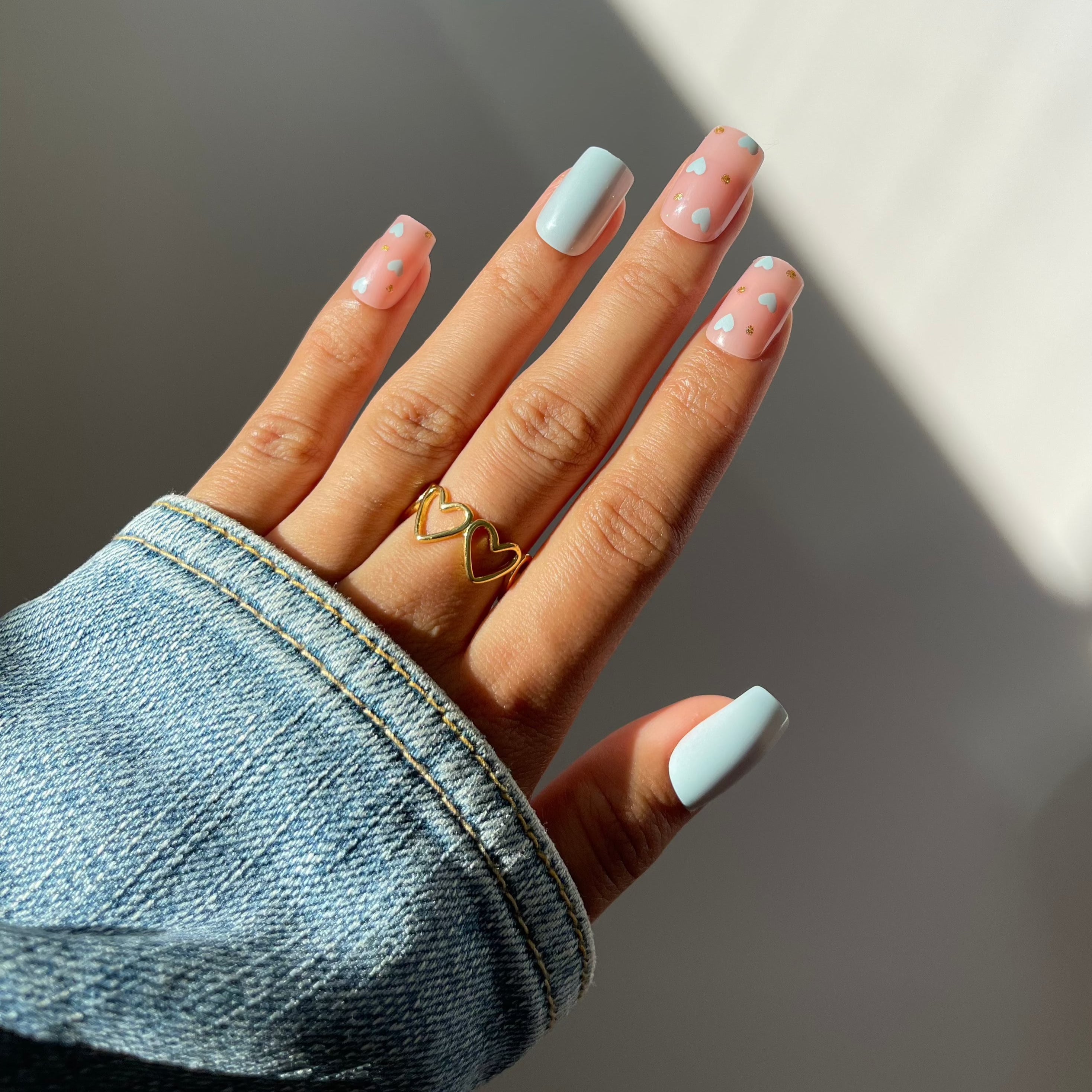 Chic square Mila press-on nails with heart accents.