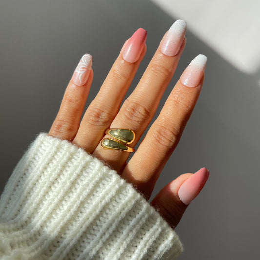 Iris press-on nails with floral design on hand, rosy gradient.