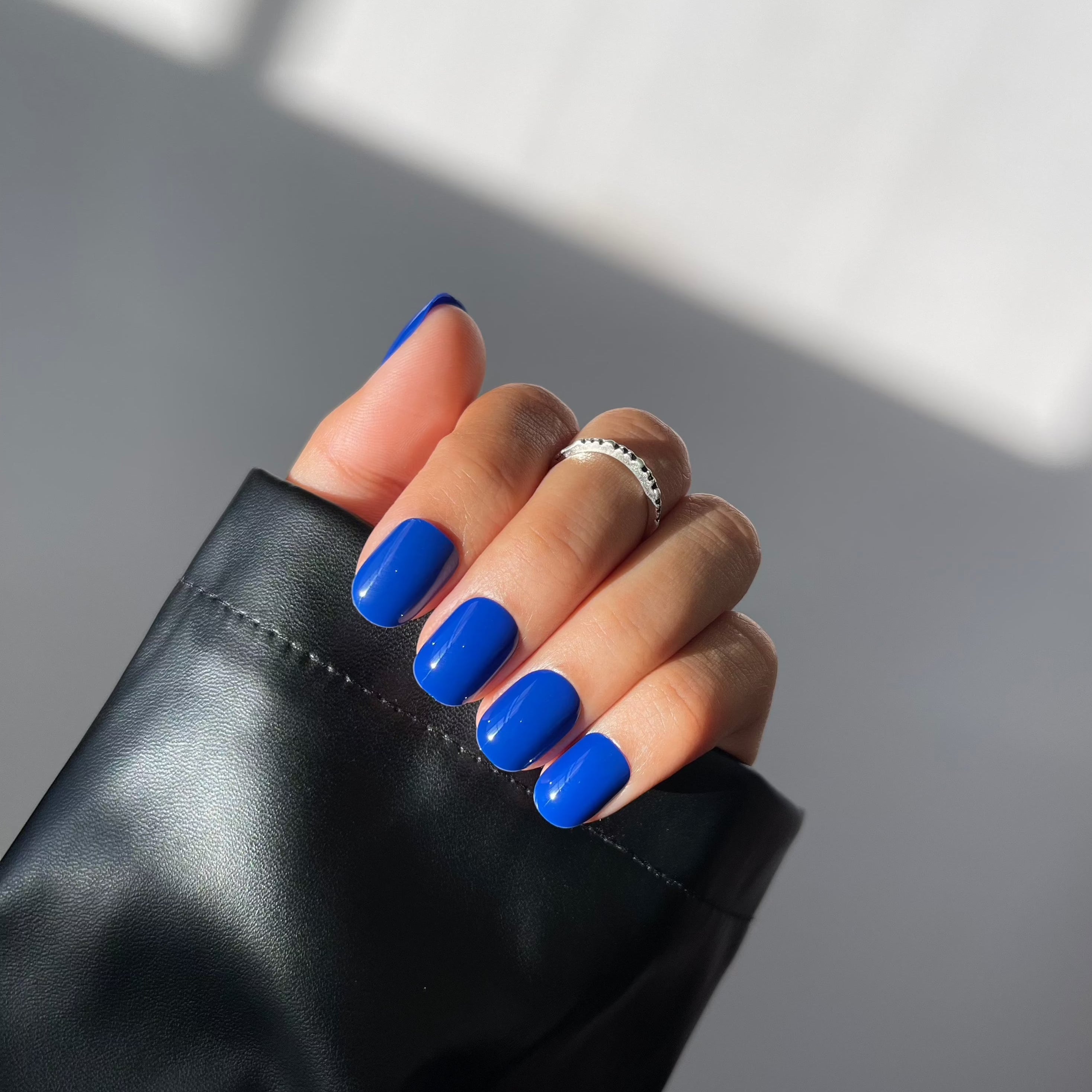 Hand with indigo press-on nails and rings