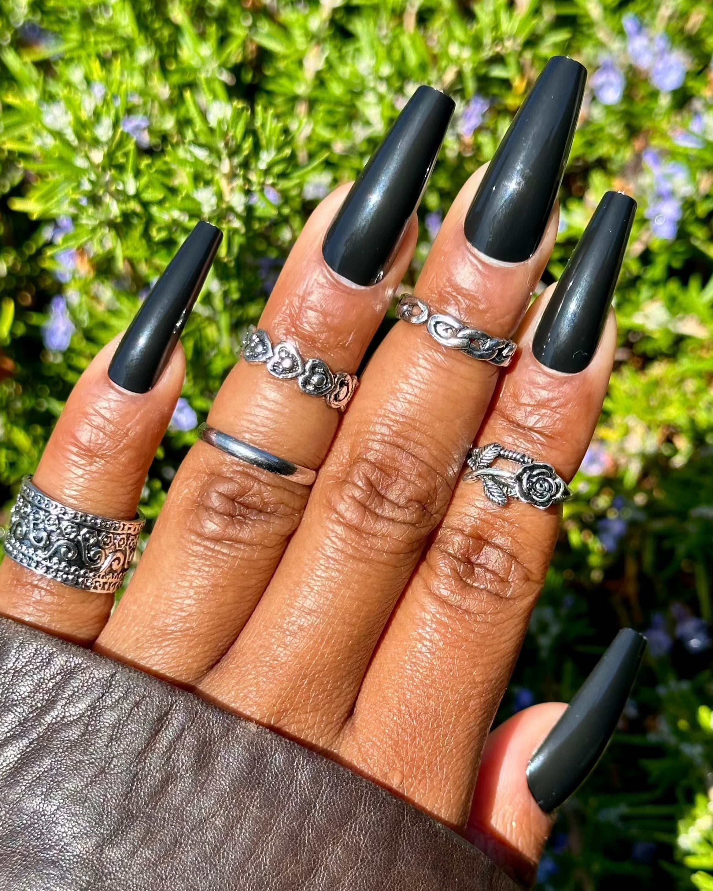 Glossy black press-on nails with silver rings