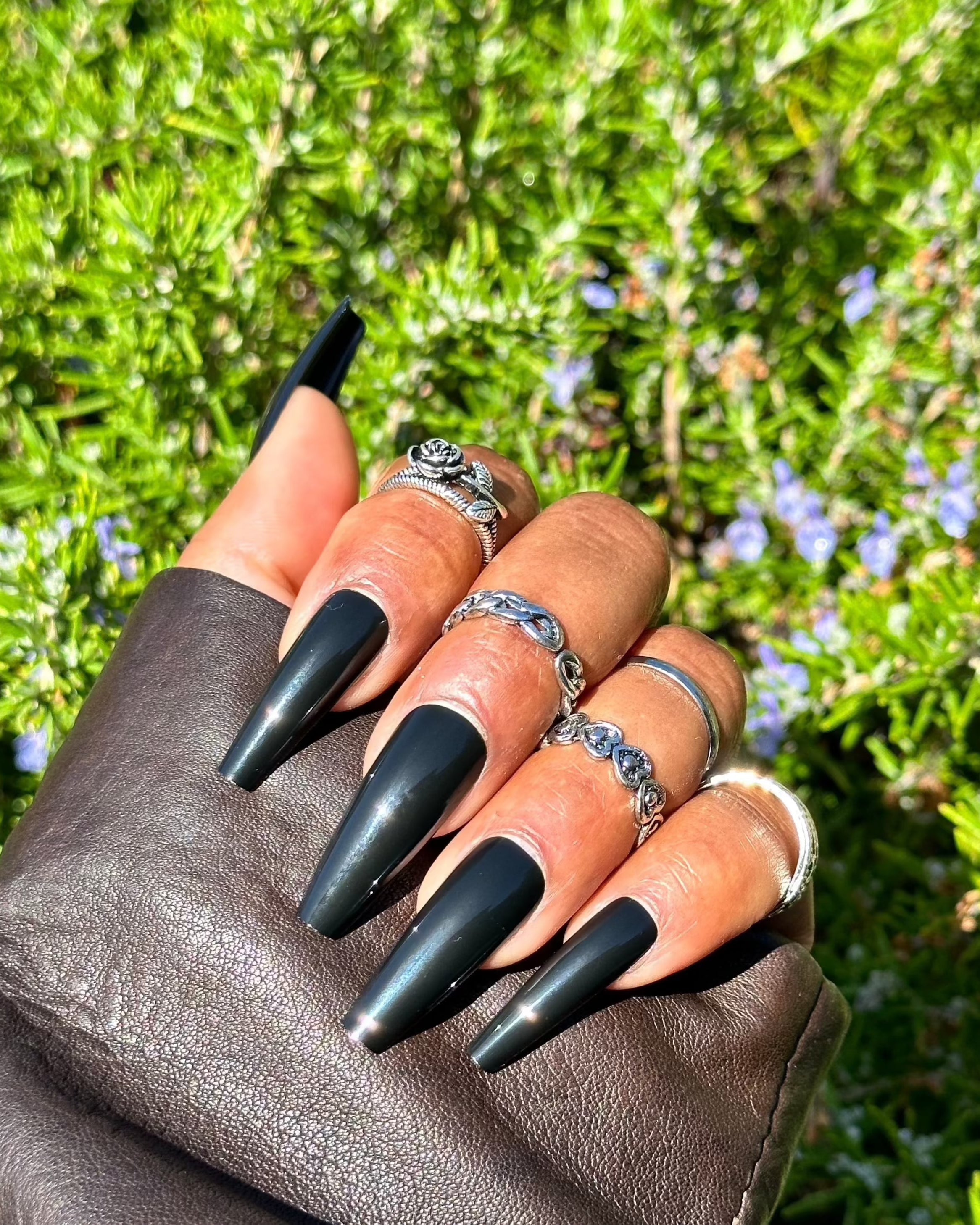 Glossy black nails with leather jacket and rings