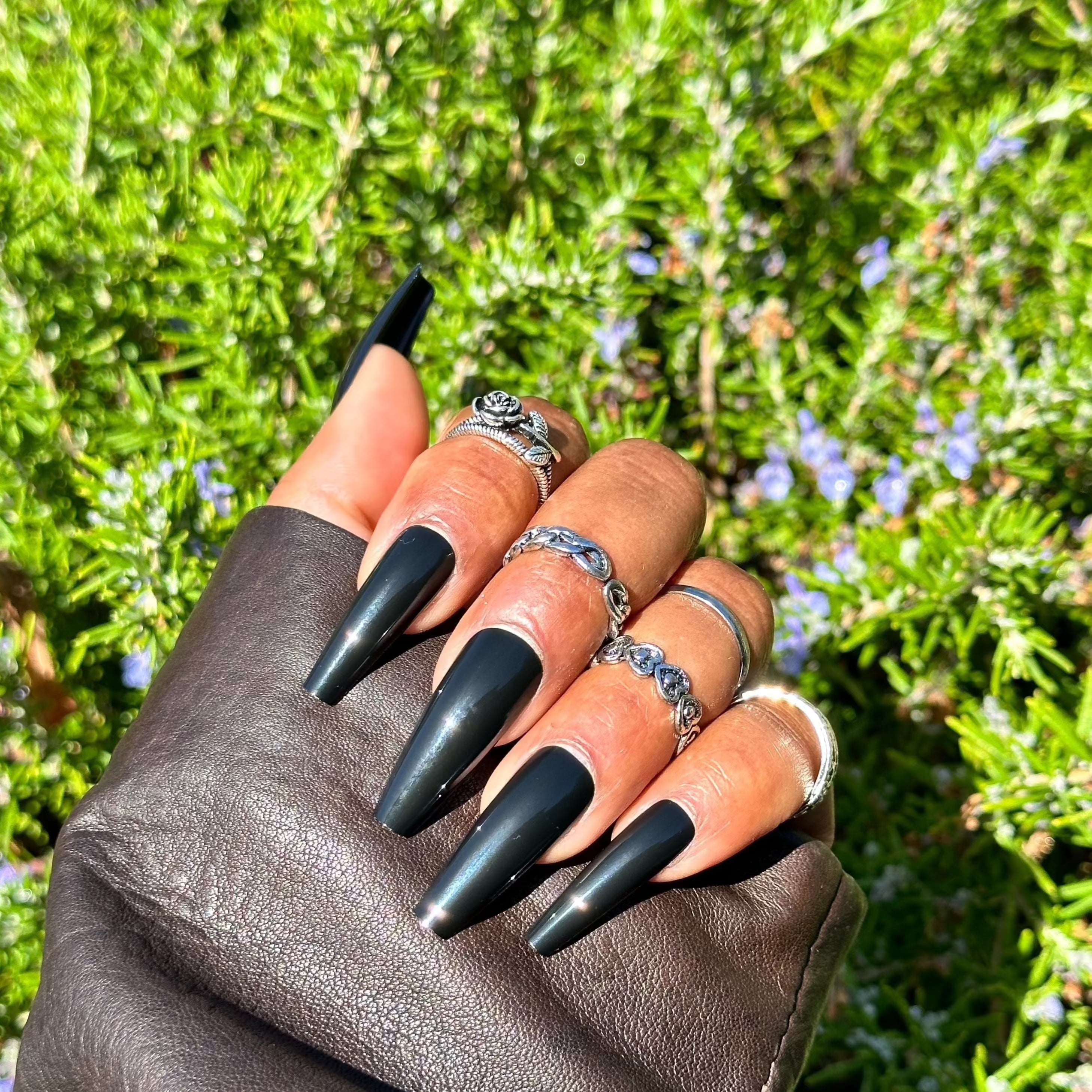 Glossy black nails with leather jacket and rings