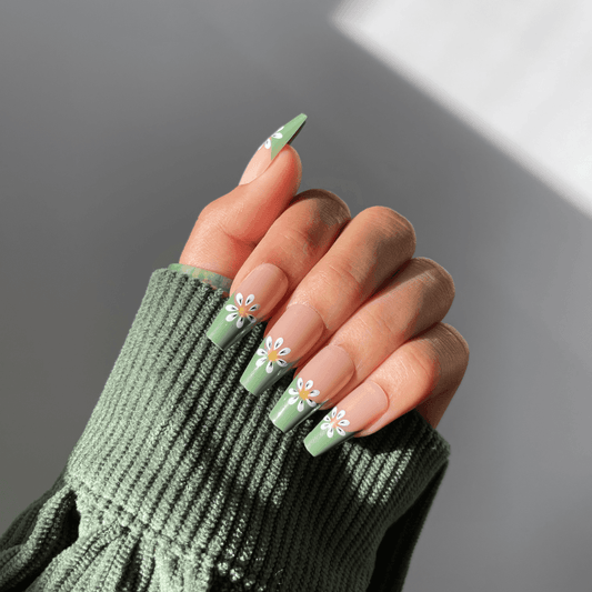 Coffin-shaped green nails with white daisy accents.
