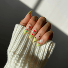 Hand with green and cherry design press-on nails