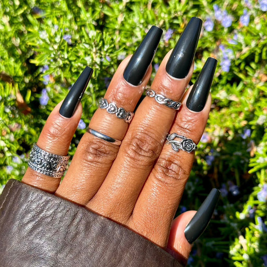 Glossy black press-on nails with silver rings