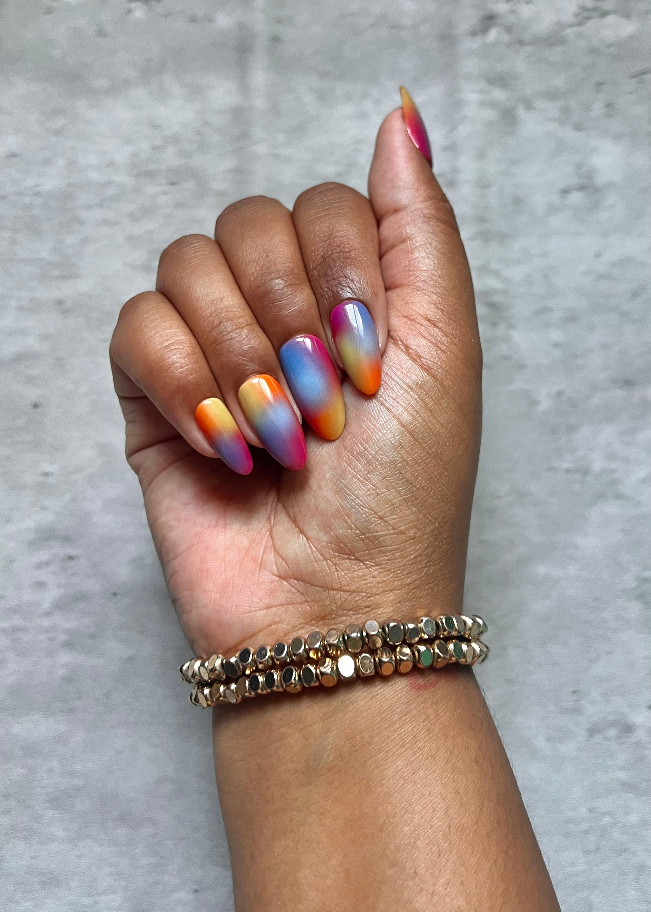Hand with multicolored Press-on nails on a gray background