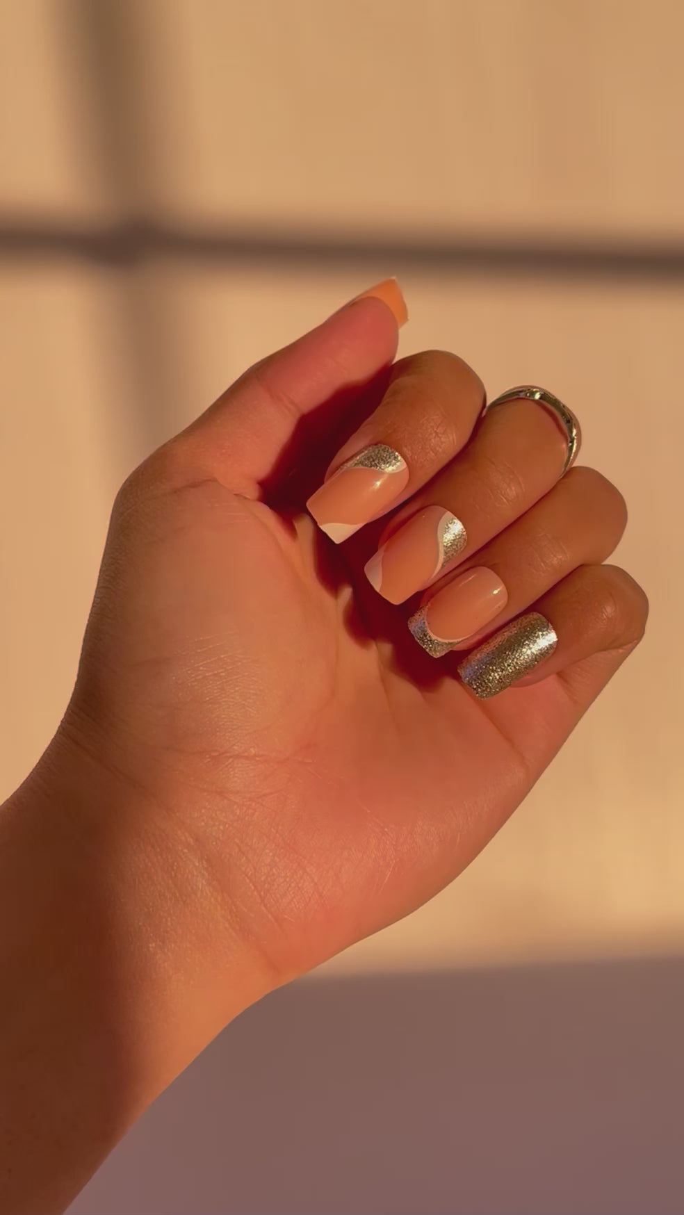 Hand displaying Celine French tip press-on nails, silver glitter