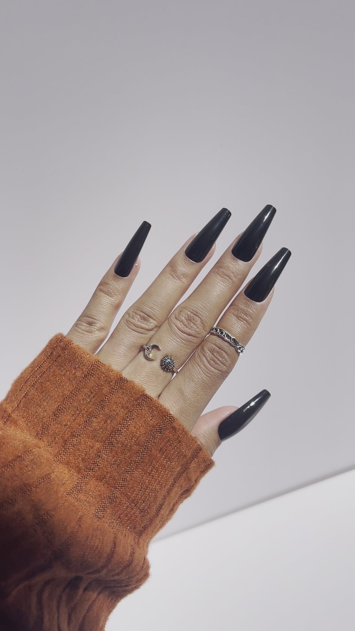 Long black press-on nails with orange sleeve